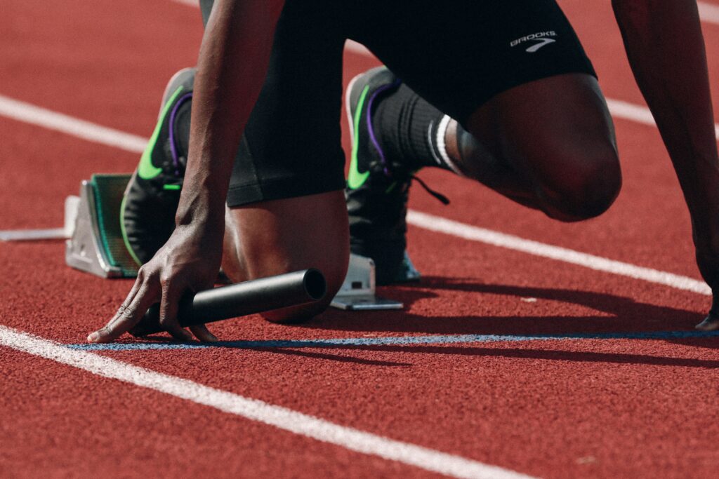 A high-performer in starting blocks representing individual coachability and readiness for behavioral change.
